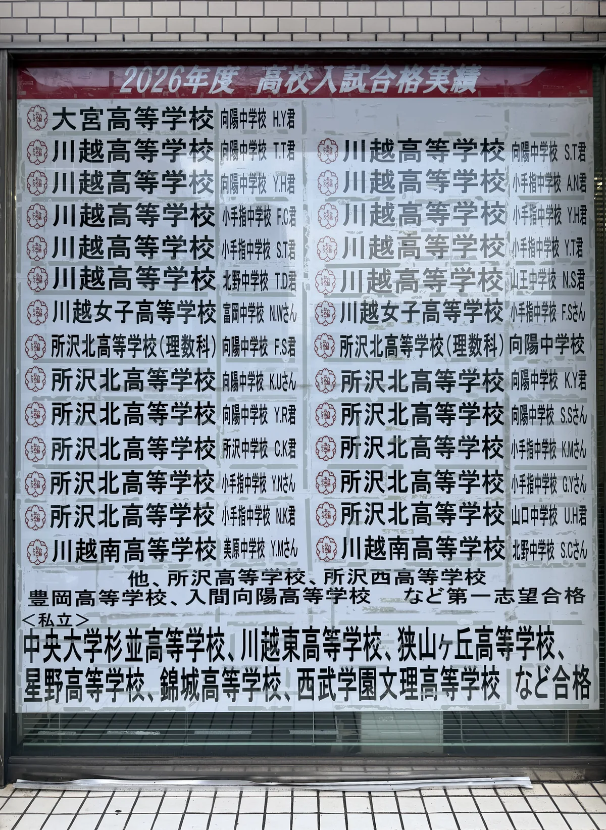 学友館の校舎の窓に掲示された2026年度 高校入試合格実績。大宮・川越・川越女子・所沢北などの校名が並ぶ