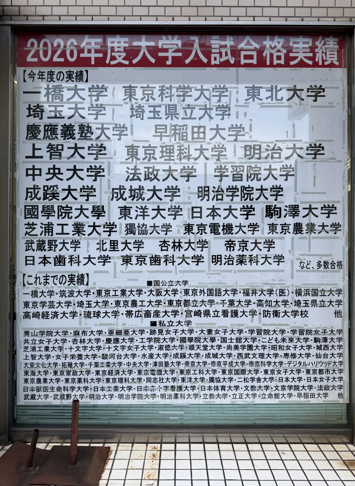 学友館の校舎の窓に掲示された2026年度 大学入試合格実績。一橋・東京科学・東北・慶應義塾・早稲田などの校名が並ぶ